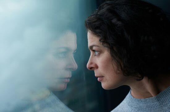 vrouw kijkt door het raam naar de buitenwereld