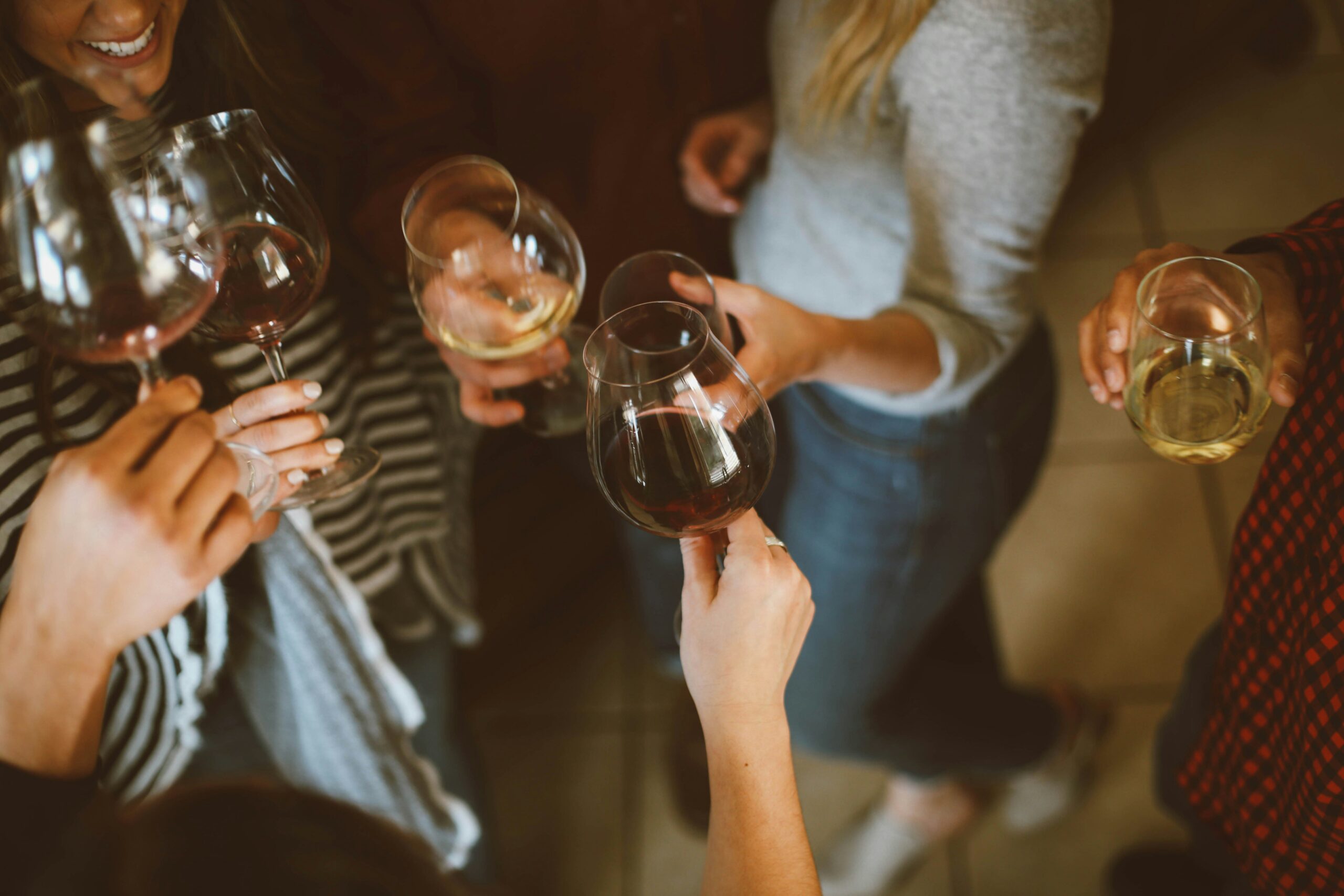proosten met groep vrienden en glazen wijn met alcohol
